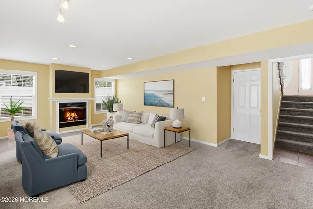a living room with furniture a flat screen tv and a fireplace