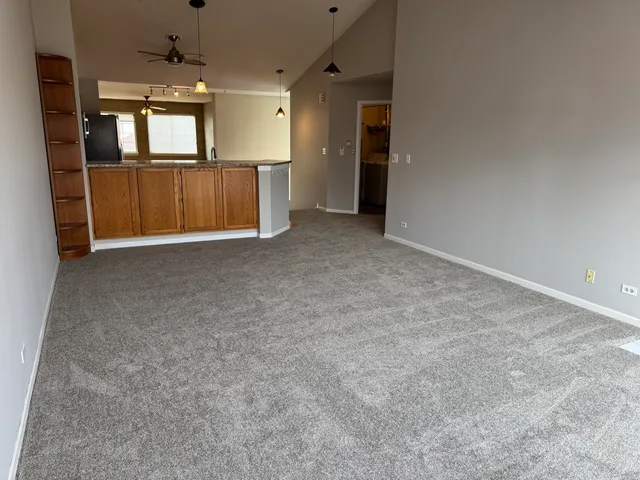 an empty room with a kitchen and a window