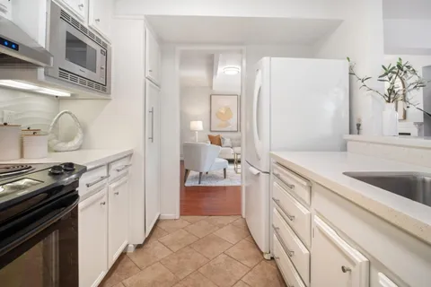 a large white kitchen with stainless steel appliances