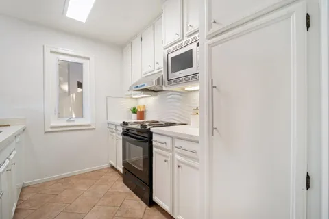 a kitchen with stainless steel appliances granite countertop a stove and a microwave