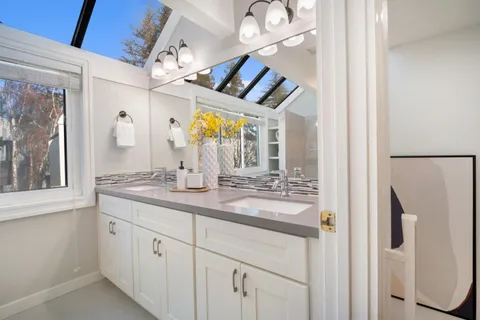 a bathroom with a granite countertop sink a mirror and a shower