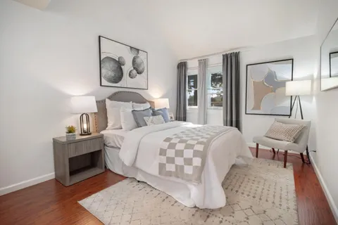 a bedroom with a bed and a lamp with wooden floor