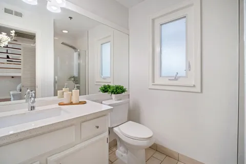 a bathroom with a toilet sink and mirror