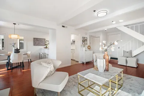 a living room with furniture a table and wooden floor