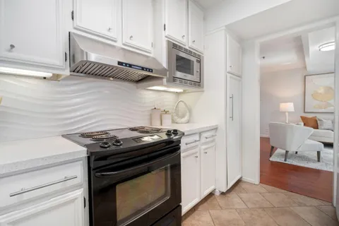 a kitchen with stainless steel appliances granite countertop a stove and a microwave