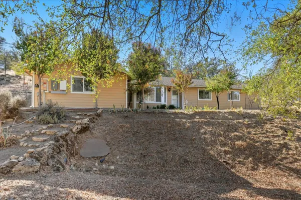 a view of a house with backyard and tree