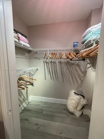 a view of walk in closet with clothes and shoes