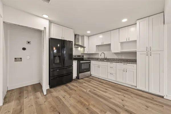 a kitchen with granite countertop white cabinets and stainless steel appliances