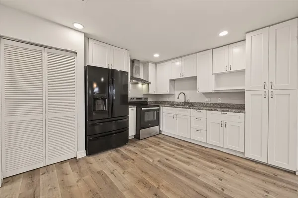 a kitchen with granite countertop white cabinets and stainless steel appliances