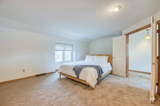 a spacious bedroom with a bed and a window