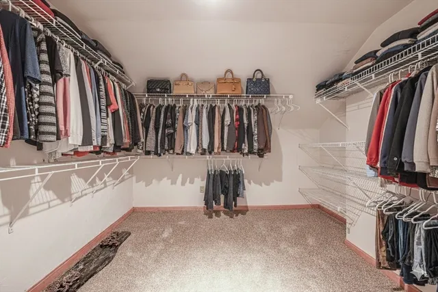 a view of walk in closet with clothes and shoes