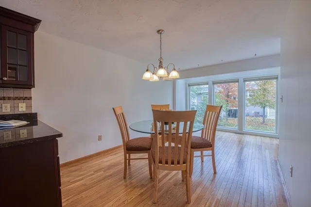 a dining room with furniture a chandelier and wooden floor
