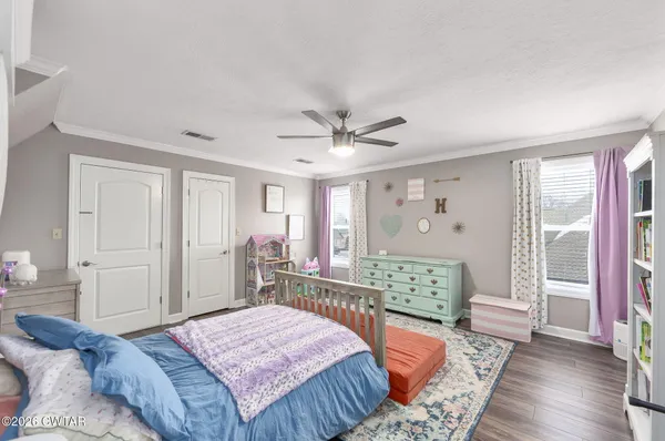 a bedroom with a bed mirror and a window