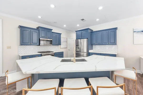 a kitchen with a table chairs stove and refrigerator