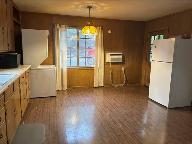 a view of a kitchen with wooden floor and electronic appliances