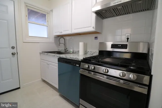 a kitchen with granite countertop a stove and a sink