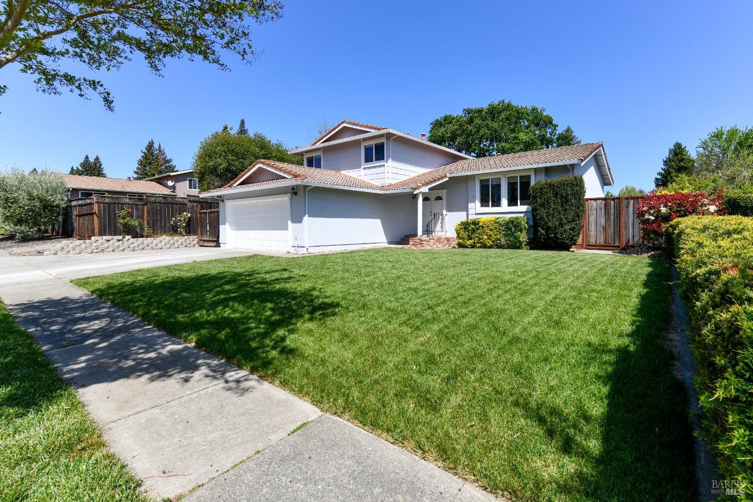 a front view of a house with a yard and potted plants