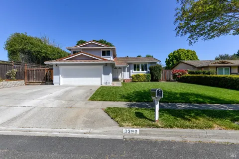 a front view of a house with a yard and potted plants