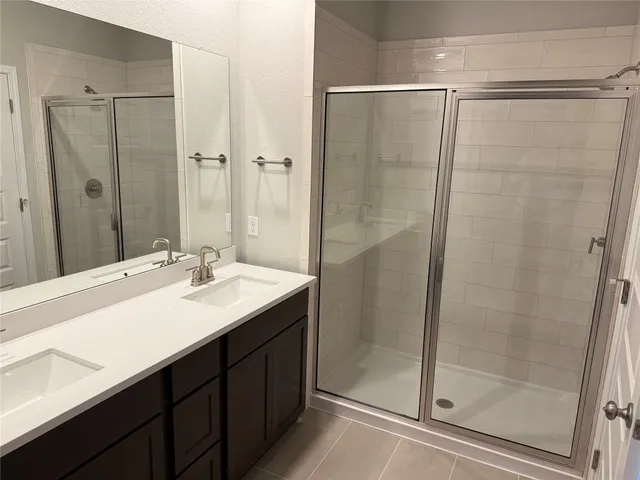 a bathroom with a shower sink vanity and mirror