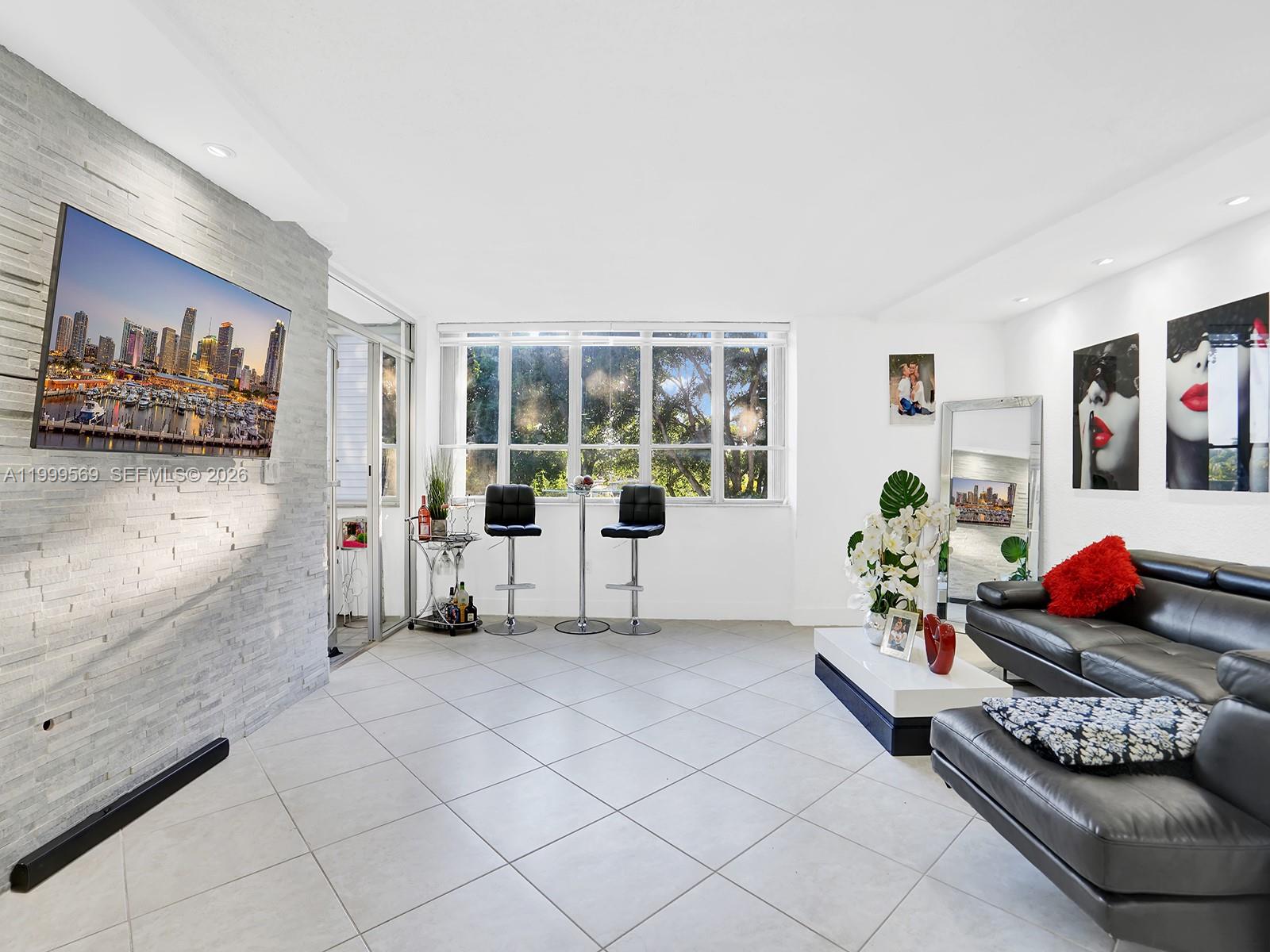 6841 Southwest 147th Avenue, Unit 2H Miami, FL 33193 - Photo 13 of 22 a living room with furniture and flowers