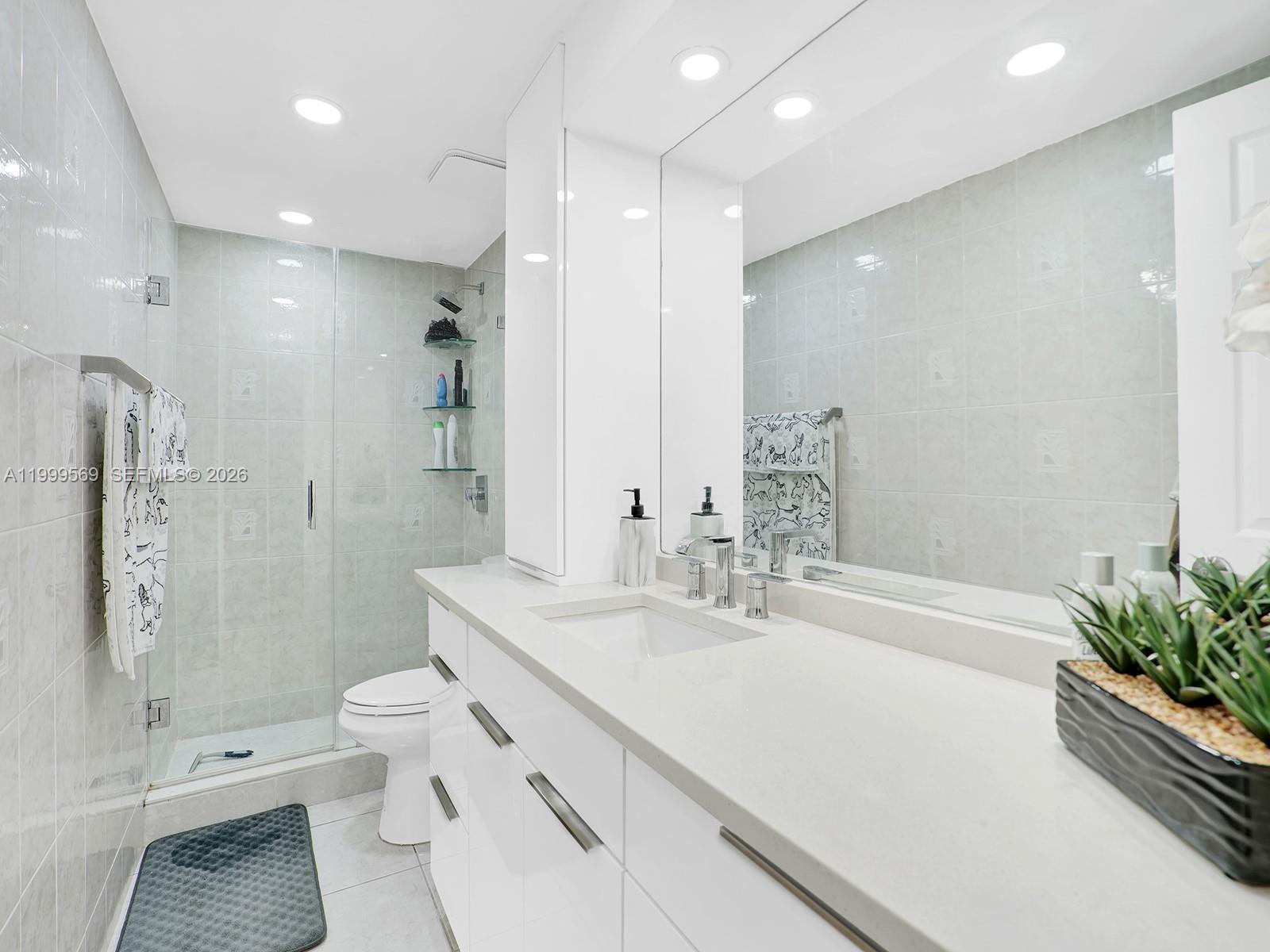 6841 Southwest 147th Avenue, Unit 2H Miami, FL 33193 - Photo 16 of 22 a bathroom with a double vanity sink toilet and shower