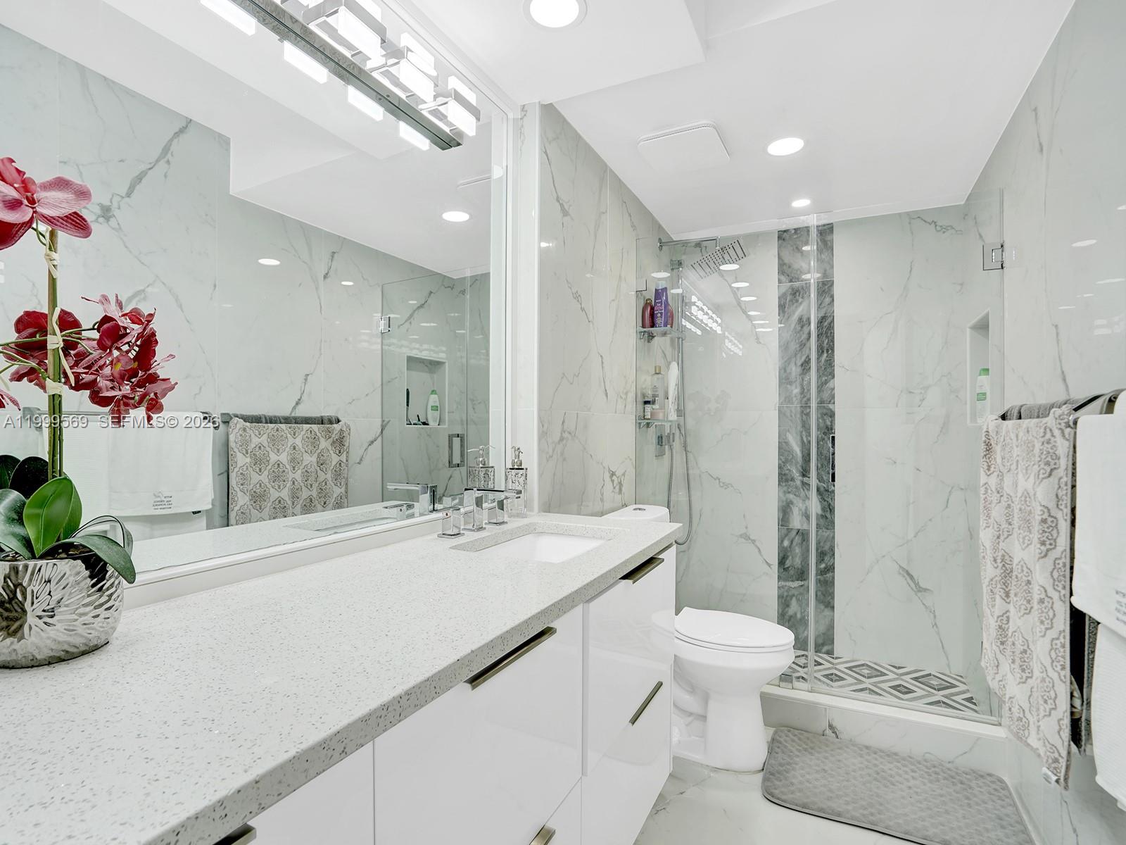 6841 Southwest 147th Avenue, Unit 2H Miami, FL 33193 - Photo 18 of 22 a bathroom with a granite countertop sink a toilet and shower