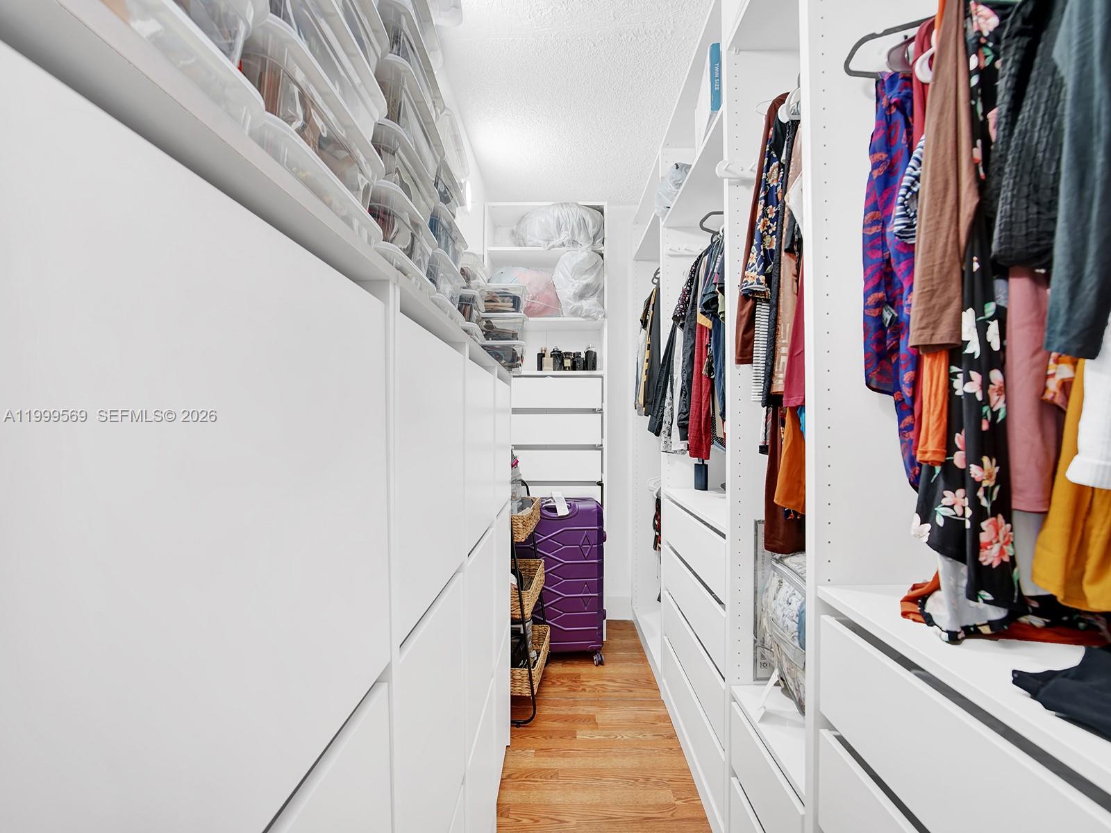 6841 Southwest 147th Avenue, Unit 2H Miami, FL 33193 - Photo 19 of 22 a view of walk in closet with clothes and shoes