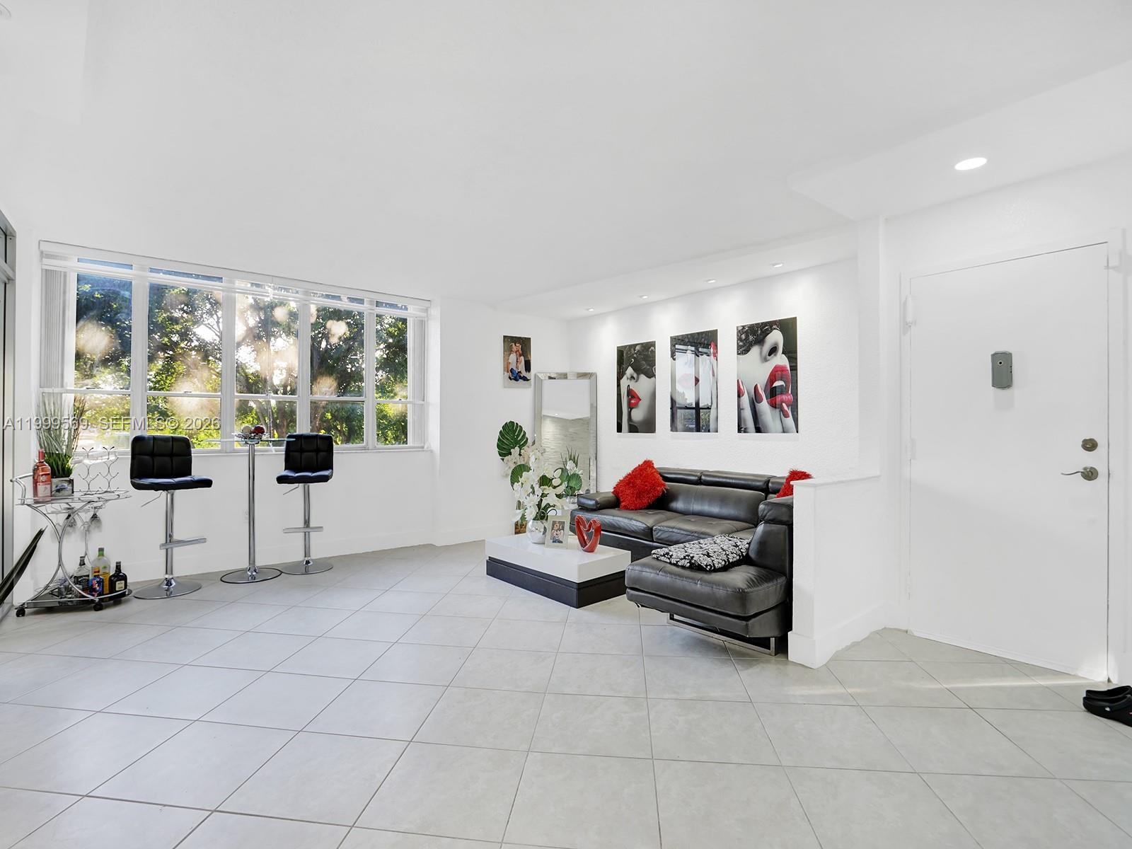 6841 Southwest 147th Avenue, Unit 2H Miami, FL 33193 - Photo 7 of 22 a living room with furniture and a flat screen tv