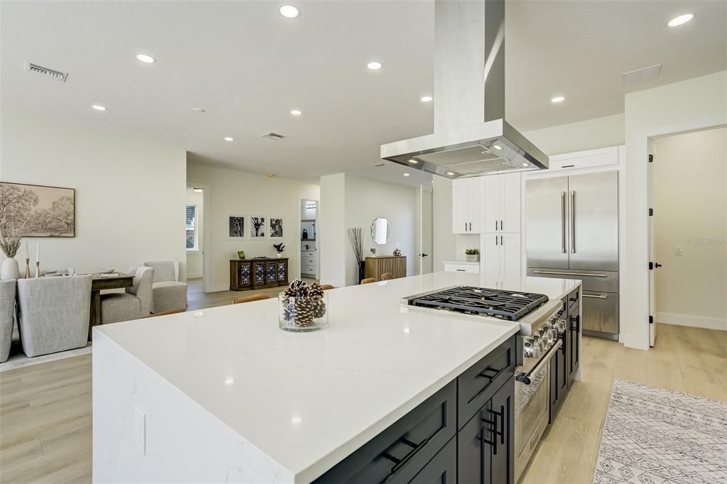 319 Cedar Lane Largo, FL 33770 - Photo 14 of 37 a kitchen with stainless steel appliances granite countertop a stove a sink a refrigerator and white cabinets with wooden floor