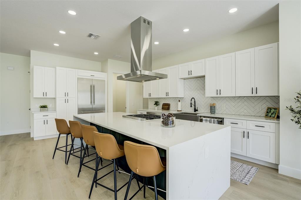319 Cedar Lane Largo, FL 33770 - Photo 9 of 37 a kitchen with stainless steel appliances granite countertop a sink a stove a refrigerator cabinets and chairs