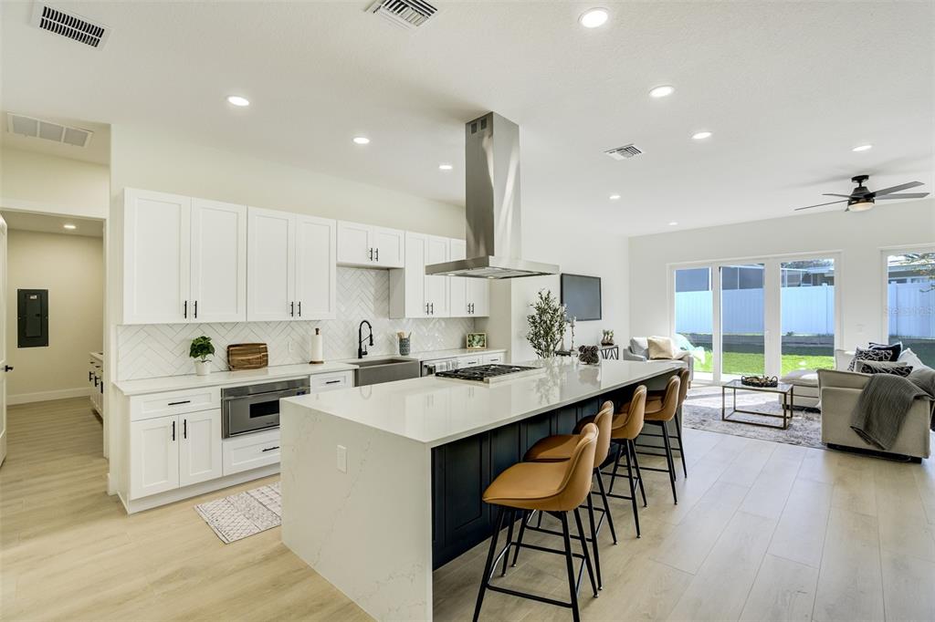 319 Cedar Lane Largo, FL 33770 - Photo 10 of 37 a kitchen with stainless steel appliances kitchen island granite countertop a table chairs sink and cabinets