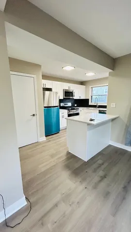 a kitchen with a sink cabinets and wooden floor