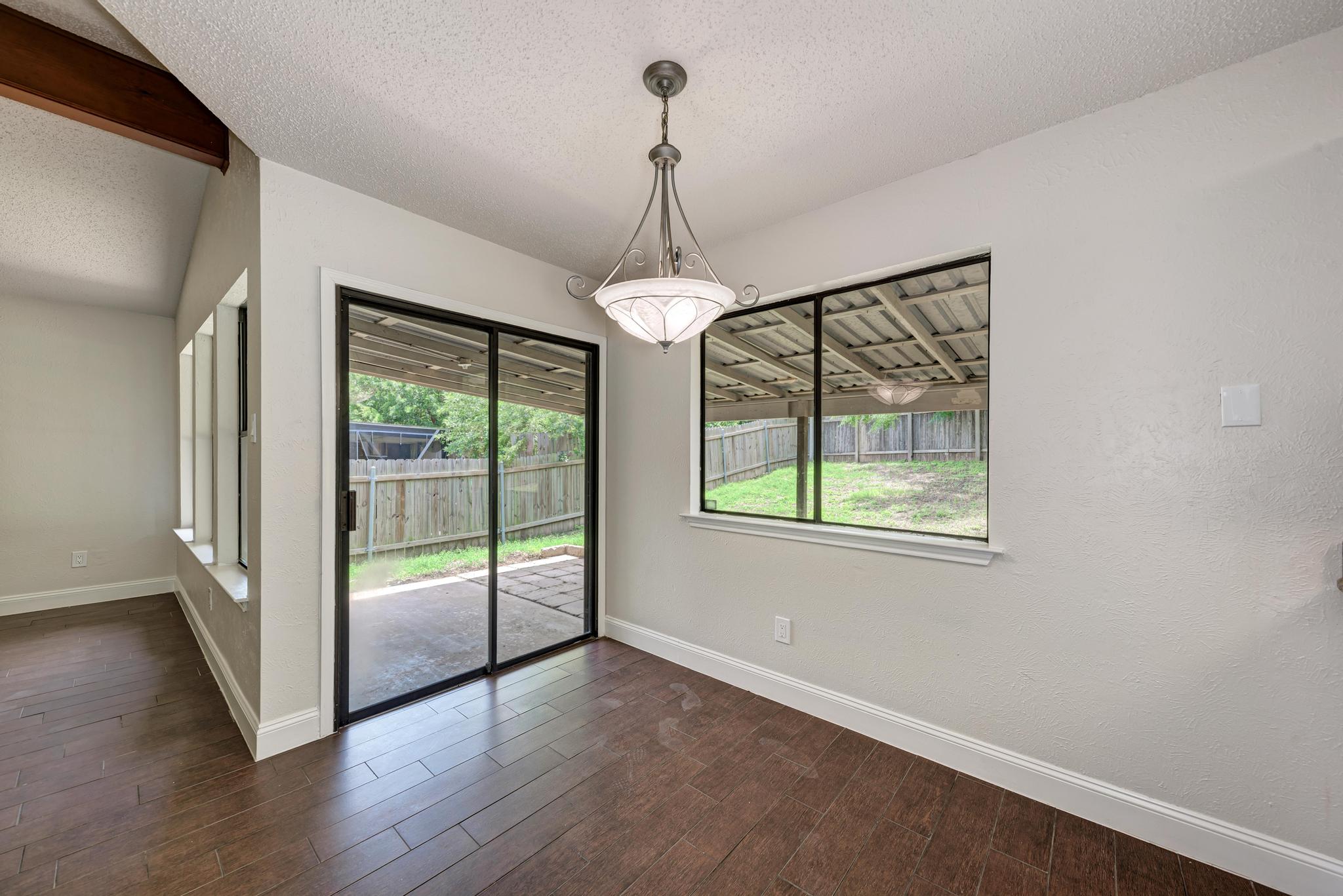 12108 Carnforth Drive Austin, TX 78753 - Photo 12 of 33 a view of a room with wooden floor a ceiling fan and windows