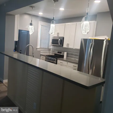 a kitchen with stainless steel appliances a refrigerator a sink a stove a microwave and island