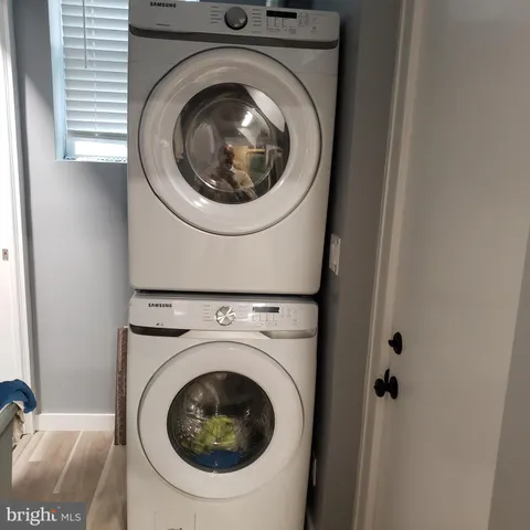 a view of a refrigerator in kitchen and an empty room