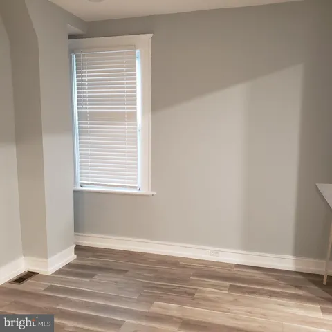an empty room with wooden floor and a window