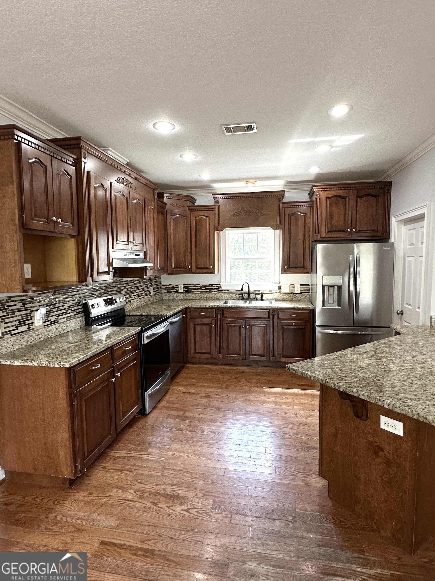 26 Alan Lane Tifton, GA 31793 - Photo 4 of 28 a large kitchen with wooden floors stainless steel appliances and a counter space