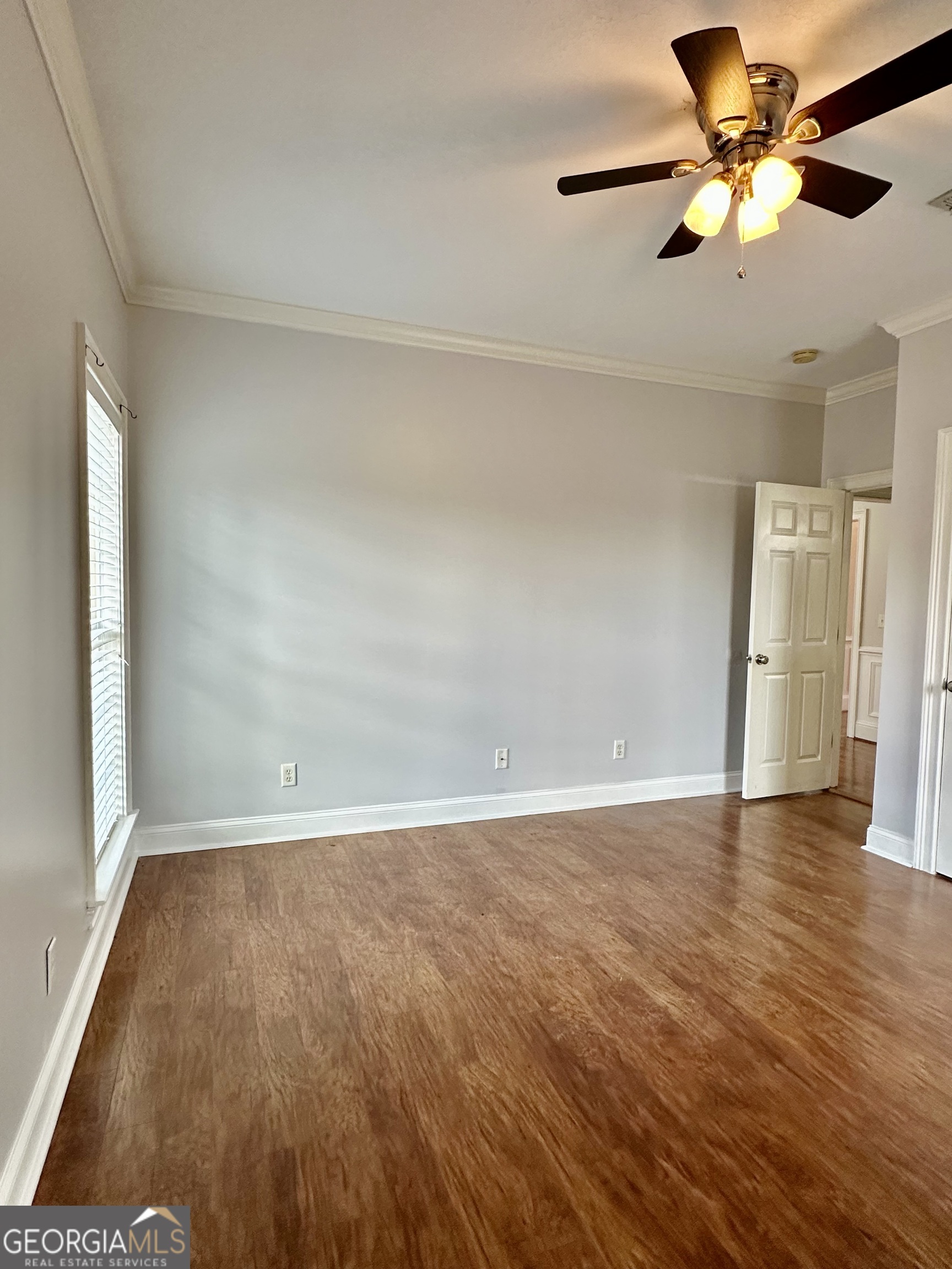26 Alan Lane Tifton, GA 31793 - Photo 6 of 28 an empty room with wooden floor fan and windows