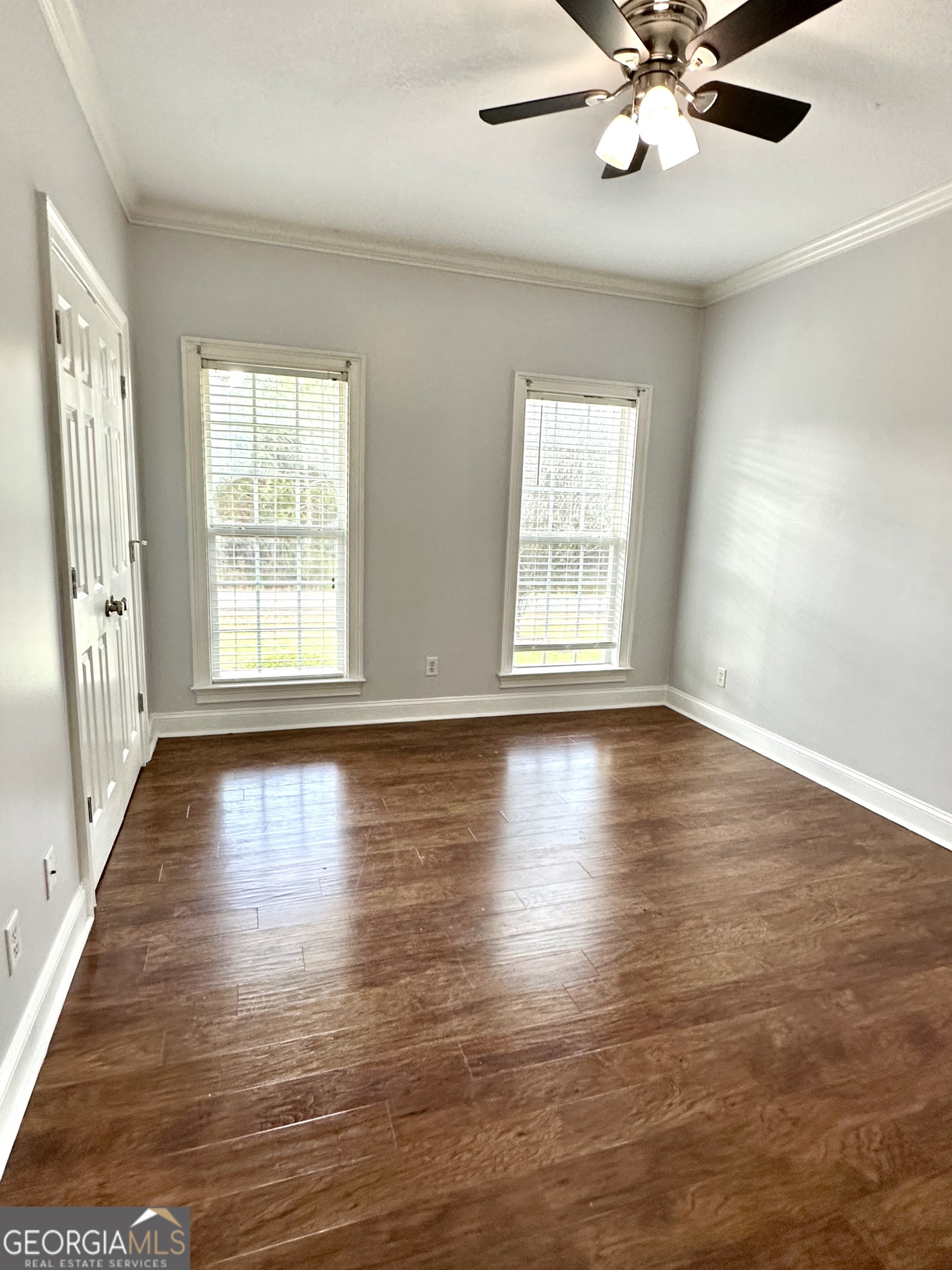 26 Alan Lane Tifton, GA 31793 - Photo 8 of 28 an empty room with wooden floor chandelier fan and windows