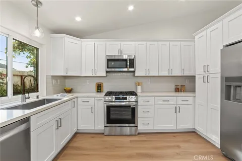 a kitchen with stainless steel appliances granite countertop a stove and white cabinets