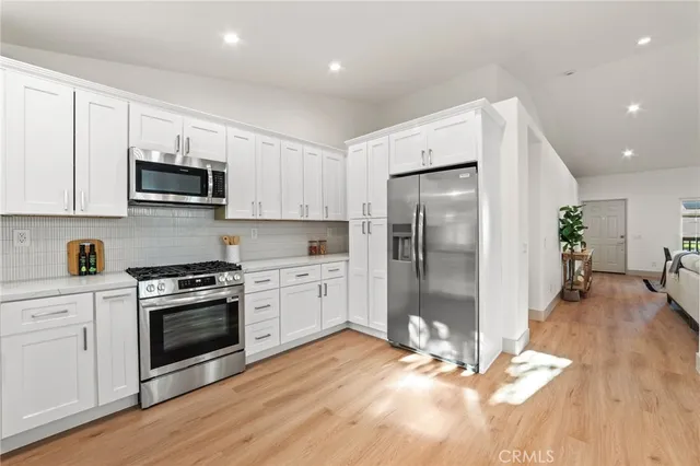 a kitchen with granite countertop a refrigerator and a stove top oven