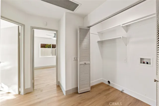 an empty room with wooden floor and closet