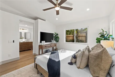 a bedroom with a bed a window and a flat screen television
