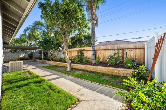 a view of a backyard with plants and a patio