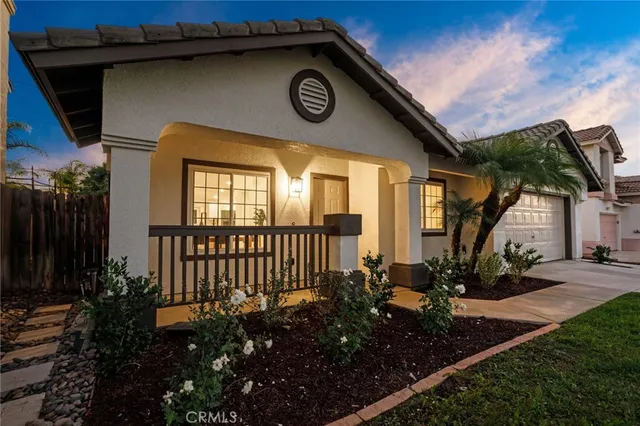 a view of a house with a porch and garden