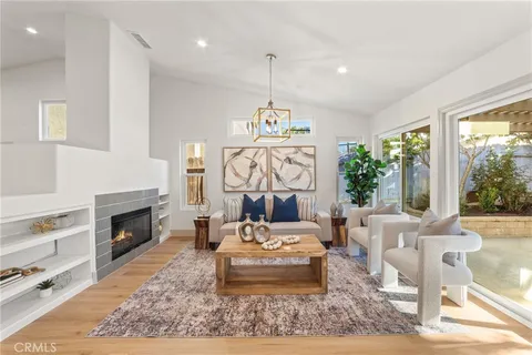 a living room with furniture a fireplace and a chandelier
