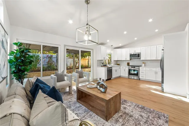 a living room with furniture kitchen and a large window