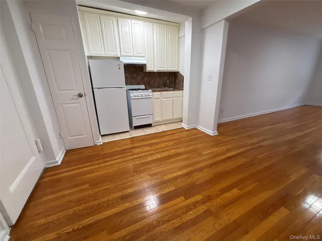 a view of a kitchen with wooden floor and electronic appliances