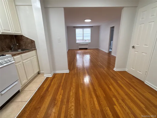 a view of a room with wooden floor and electronic appliances