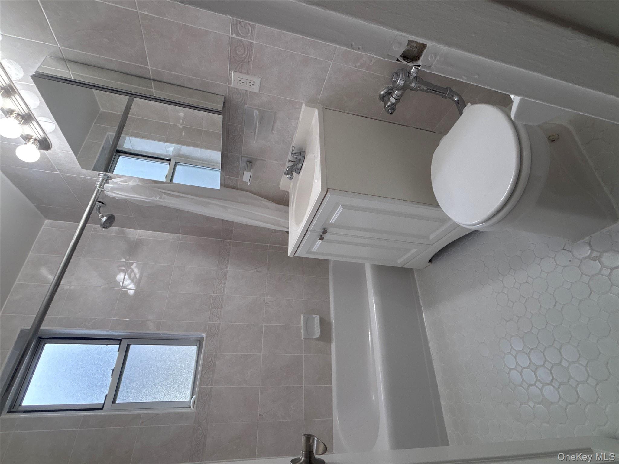 50 South Middle Neck Road, Unit 2L Great Neck, NY 11021 - Photo 6 of 12 a white toilet sitting next to a bath tub